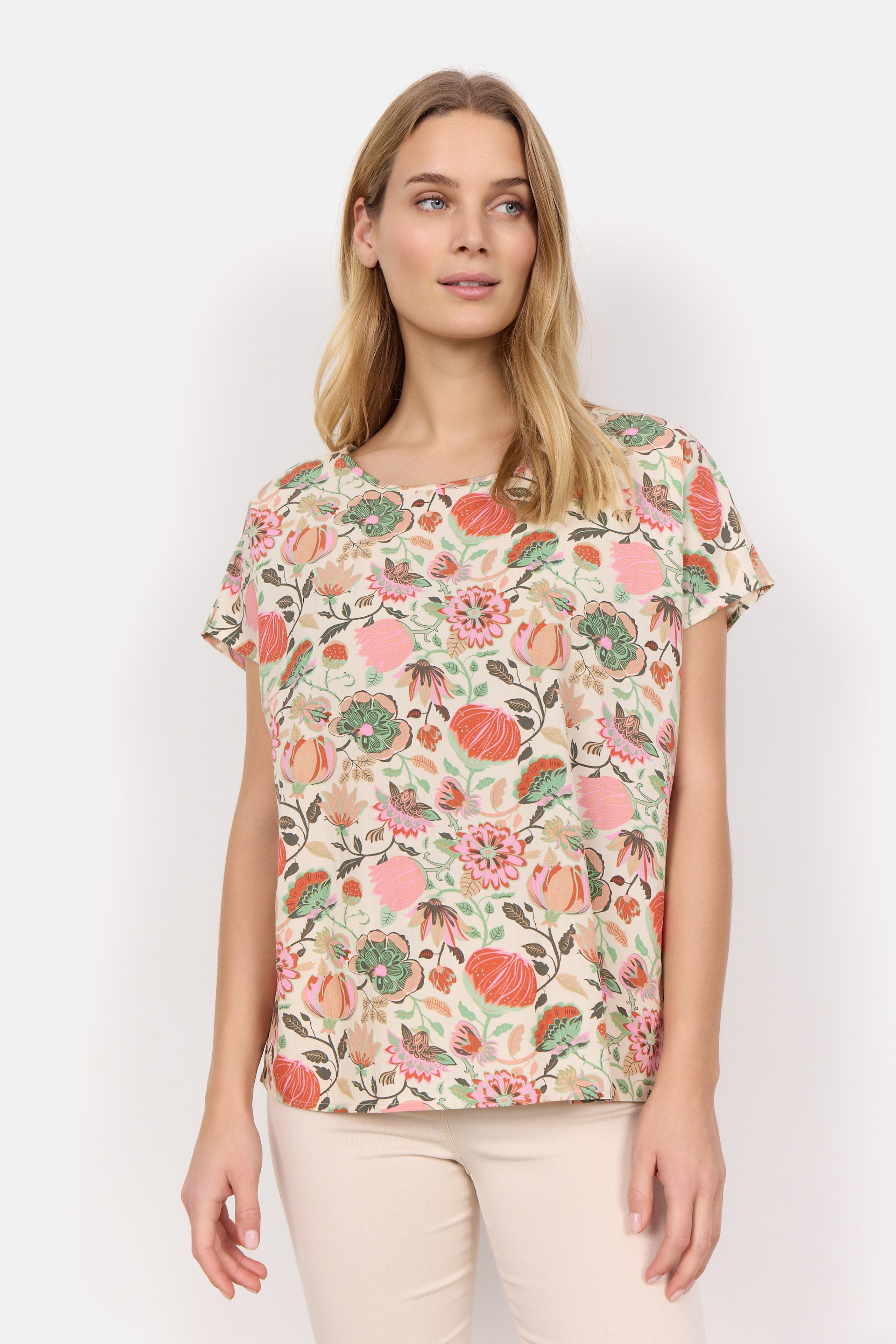 Front view of Soya Concept (40579) Women's Short Sleeve Graphic Floral Blouse in a Peach Floral Print With PInk & Green Hues over a Cream Background 