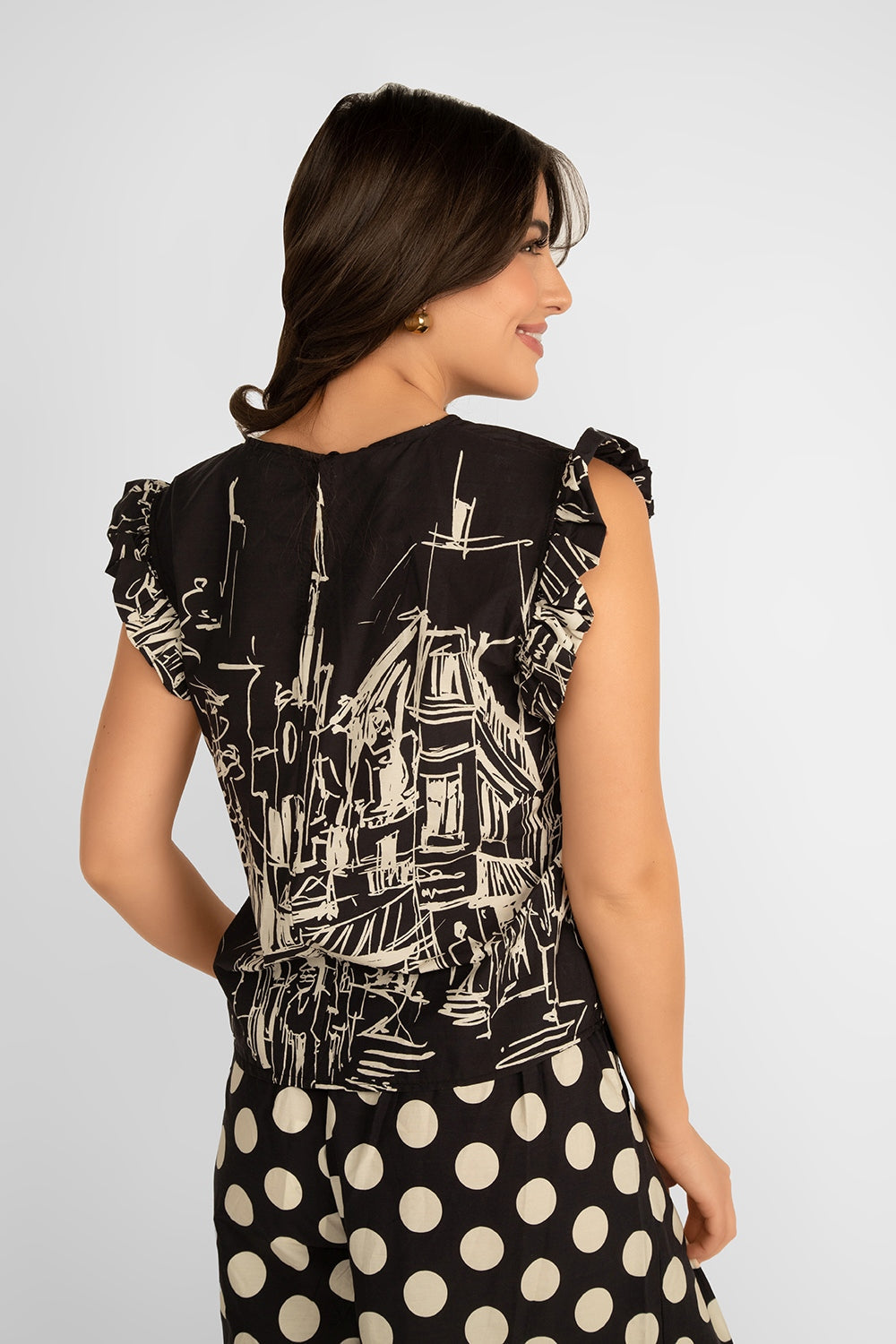 Back view of Julietta (10-A9555-C12CITY) Women's Sleeveless Ruffle Shoulder Illustrated City Print Blouse in Black & Cream