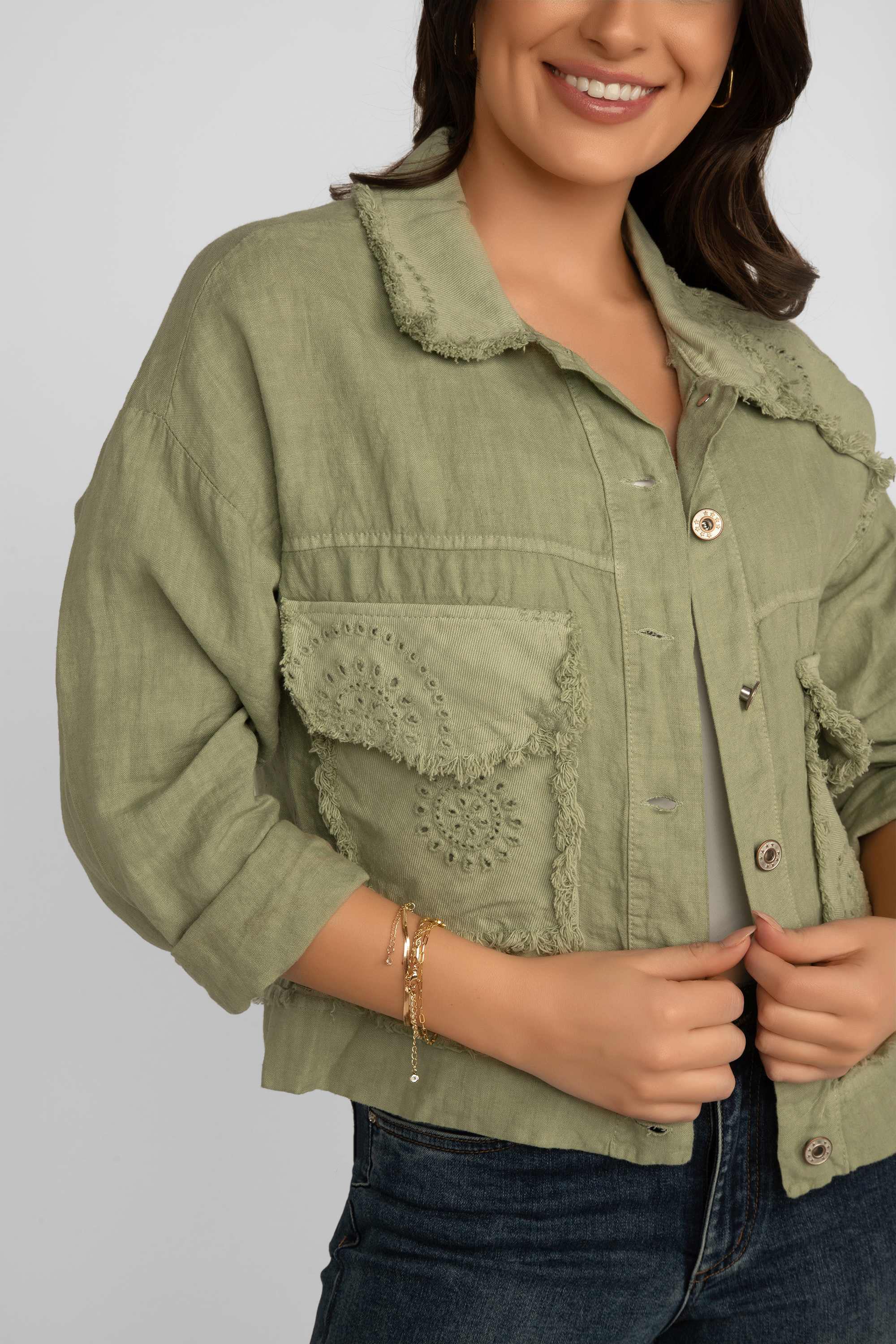 Close up front view of Elissia (NF20493) Women's Long Sleeve Frayed Hem Patch Pocket Jacket with Eyelet Lace Detail in Olive