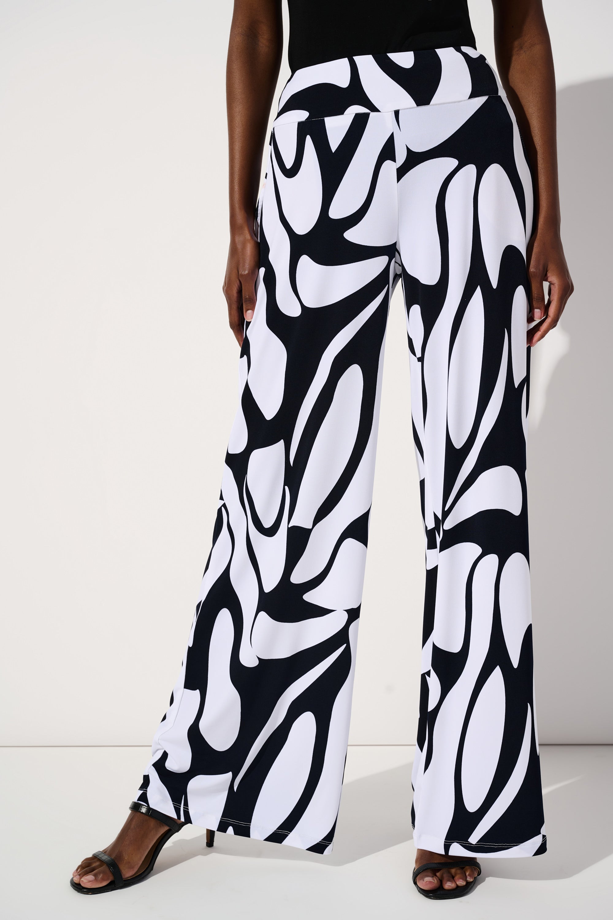 Front view of Joseph Ribkoff (242103) Women's Silky Knit Wide Leg Pants with Pockets in a Navy & White Geometric Print