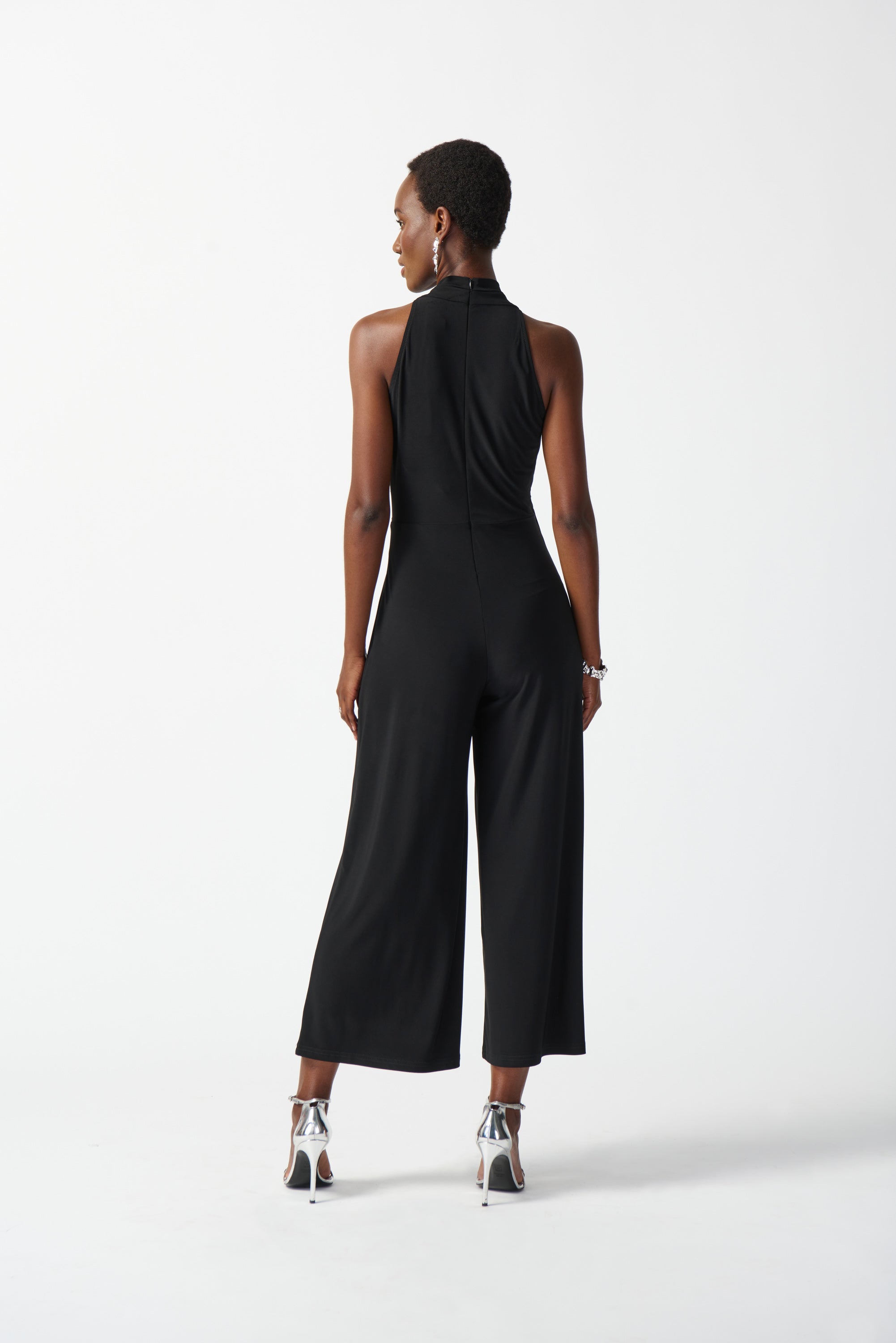 Back view of Joseph Ribkoff (242197) Women's Sleeveless Silky Knit Wrap Culotte Jumpsuit with Ornamental Side Buckle in Black