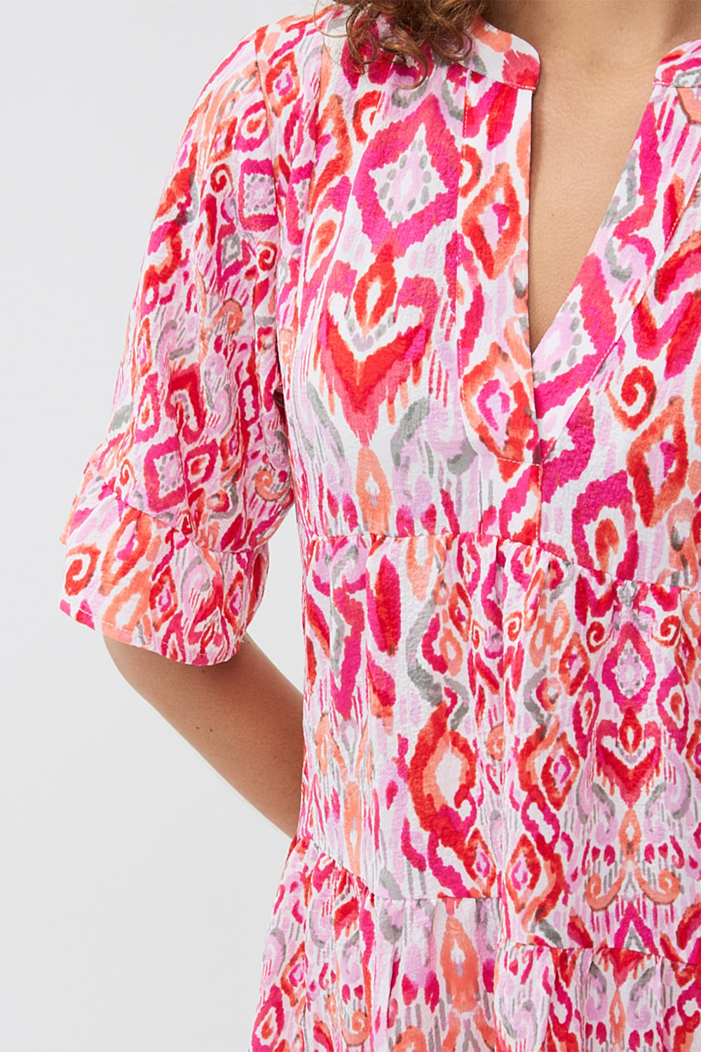 Front close up on print on EsQualo (HS2415214) Short Sleeve Pink Ikat Printed Seersucker Dress with tiered mini skirt, split v-neck and a relaxed fit 
