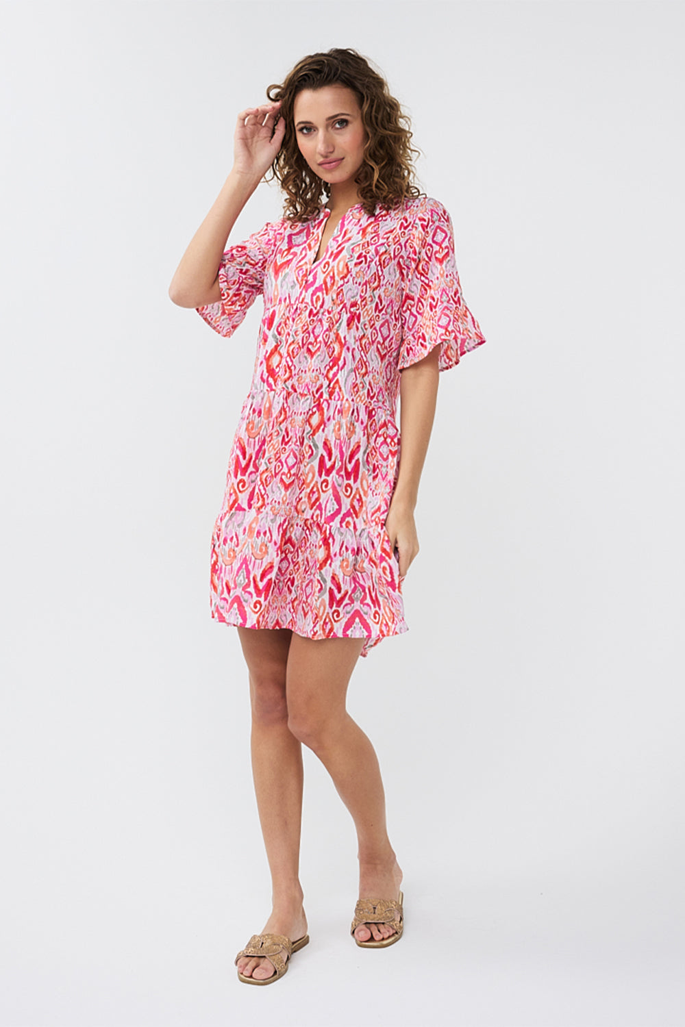 Front full body view of EsQualo (HS2415214) Short Sleeve Pink Ikat Printed Seersucker Dress with tiered mini skirt, split v-neck and a relaxed fit 