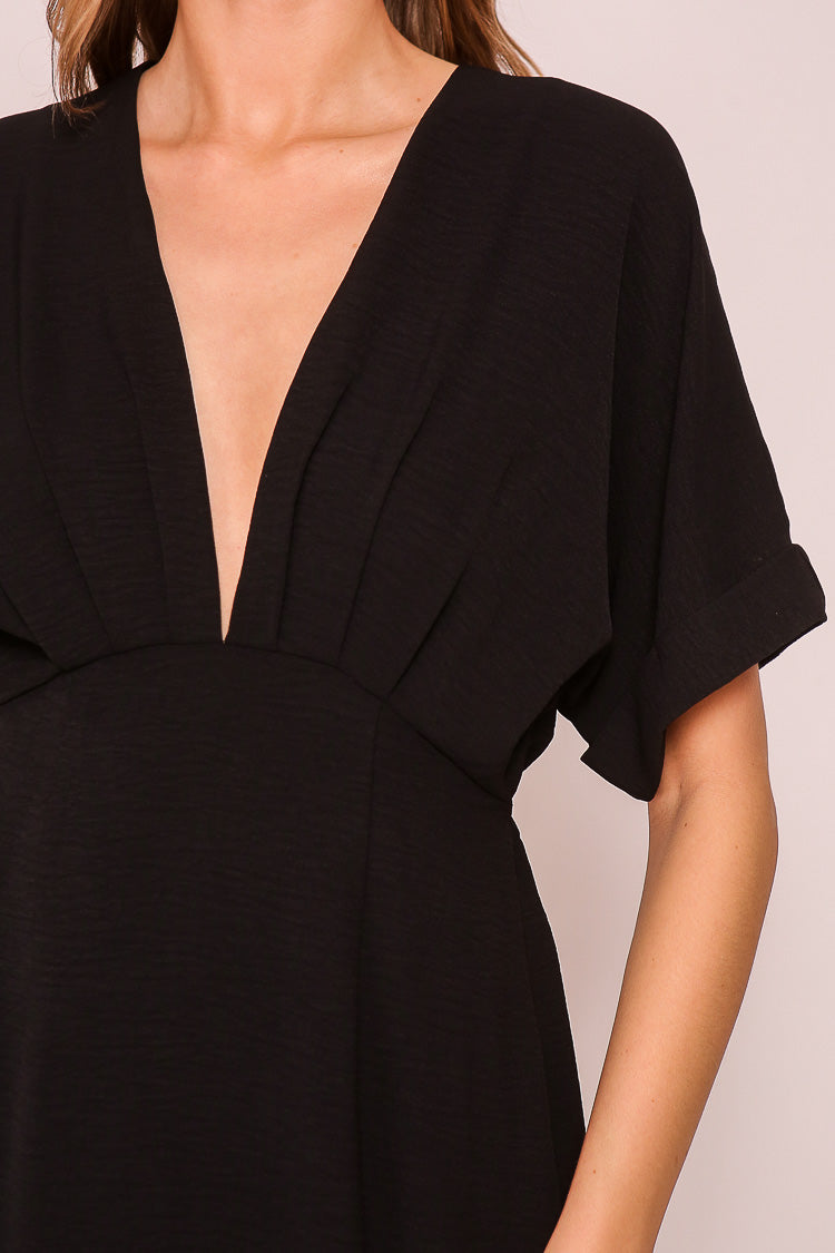 Close up of plunging V-neck on Timing (MD1924) Women's Short Sleeve Pleated Midi Dress with Plunging V-neck and back with Back Tie in Black