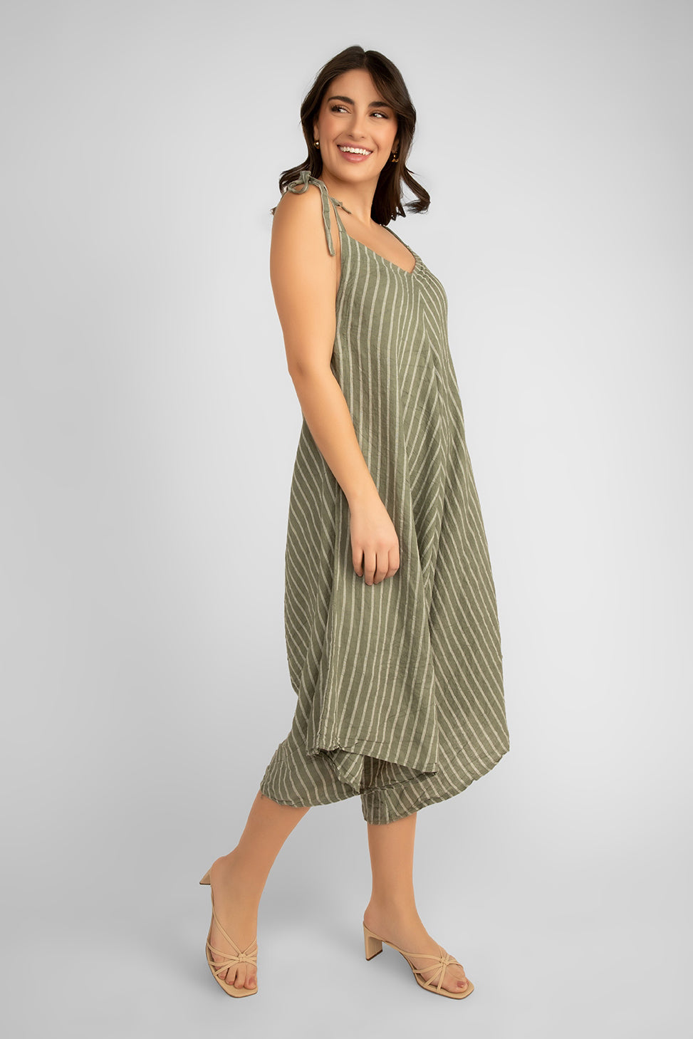 Side view of Women's (19-S59069) Women's Sleeveless Striped Linen Romper with adjustable tie straps, v-neck, and a cropped wide leg fit in Khaki & white stripes