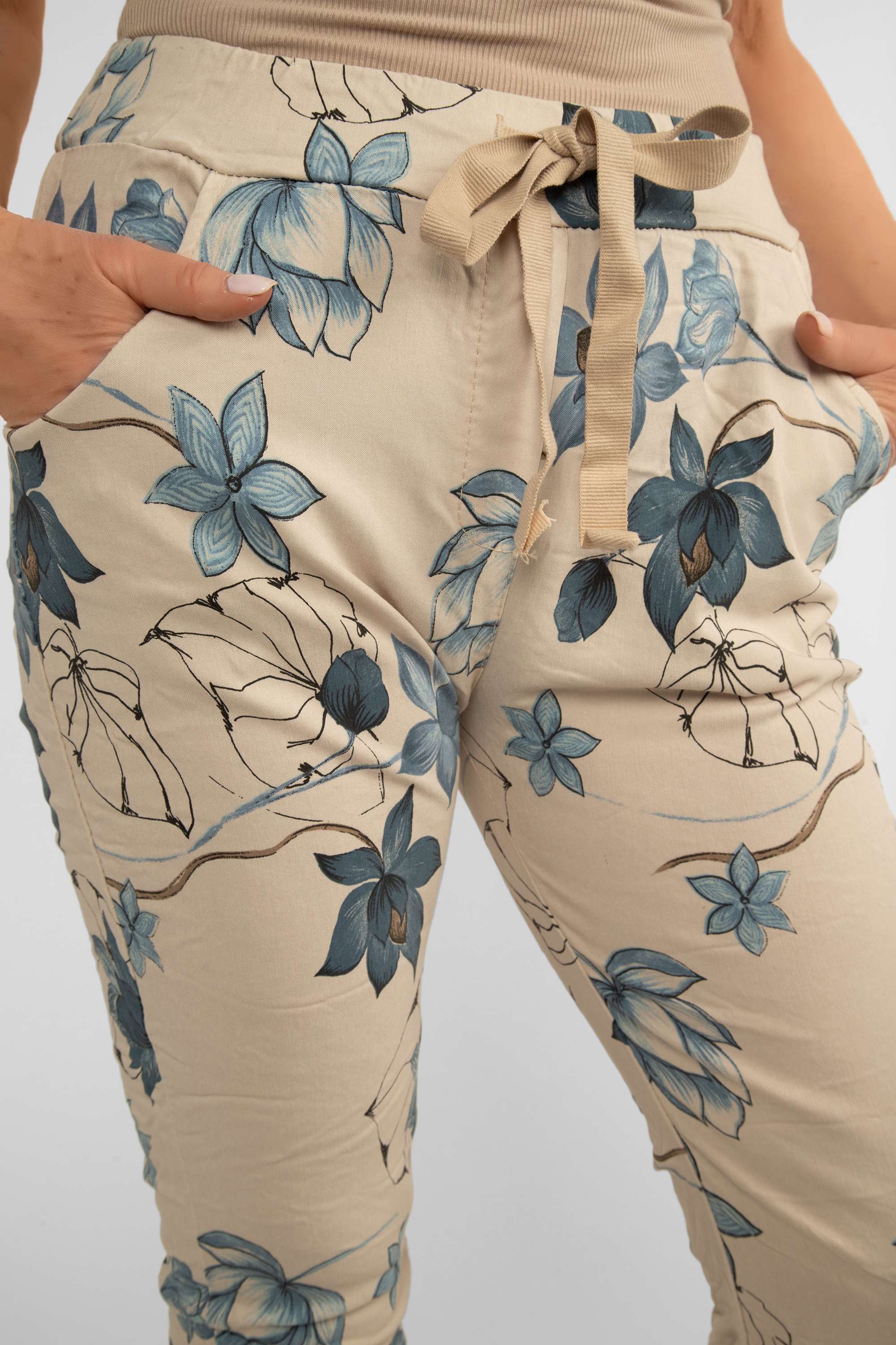Front close up of Bella Amore (21036) Women's Pull On Crinkle Pants with Side Pockets, Rolled Hem, and Blue Lotus Flower Print in Beige