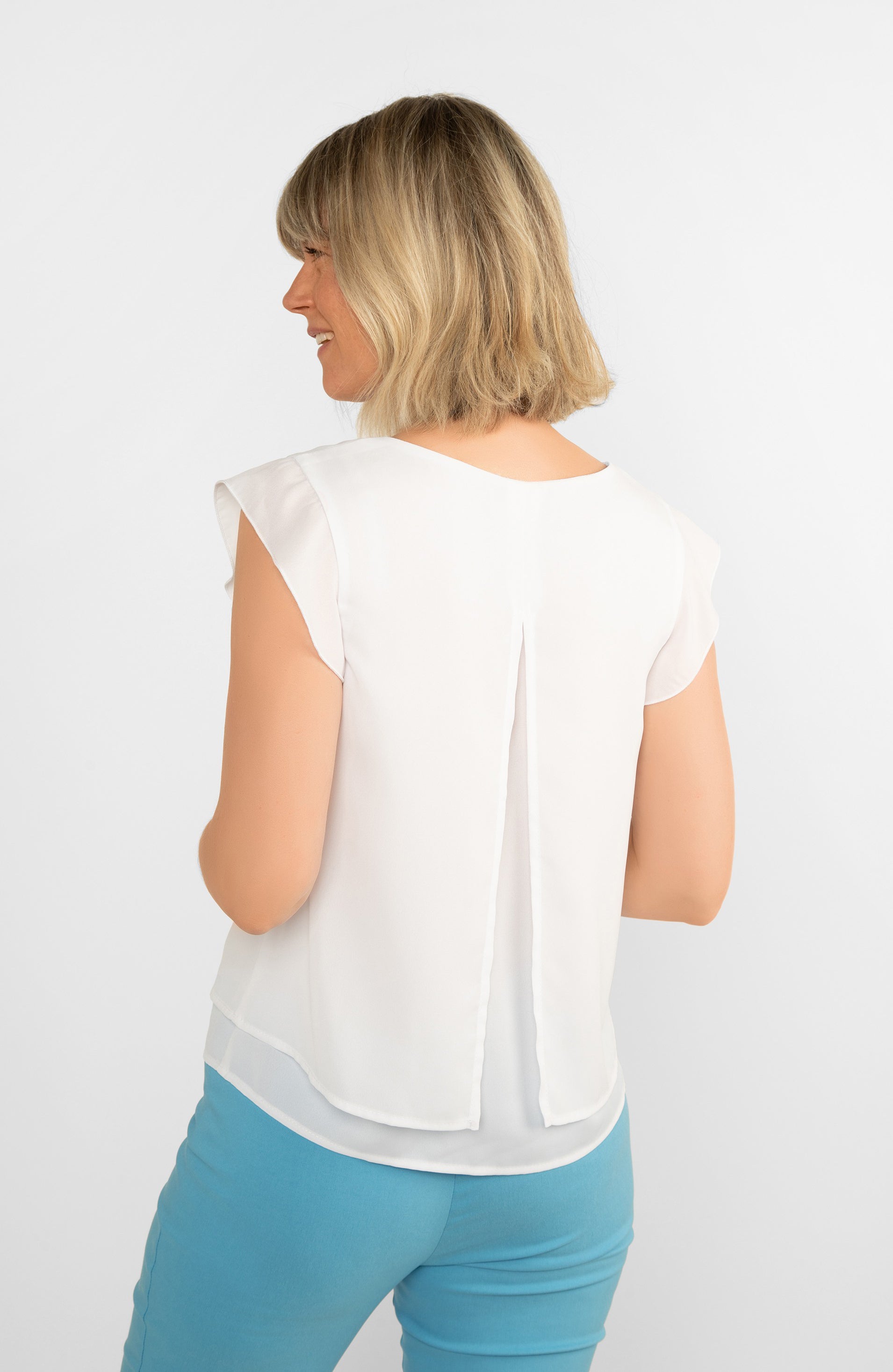 Back view showing back split on Frank Lyman (246324) Women's Sleeveless V-neck Ruffle Trim Blouse in White