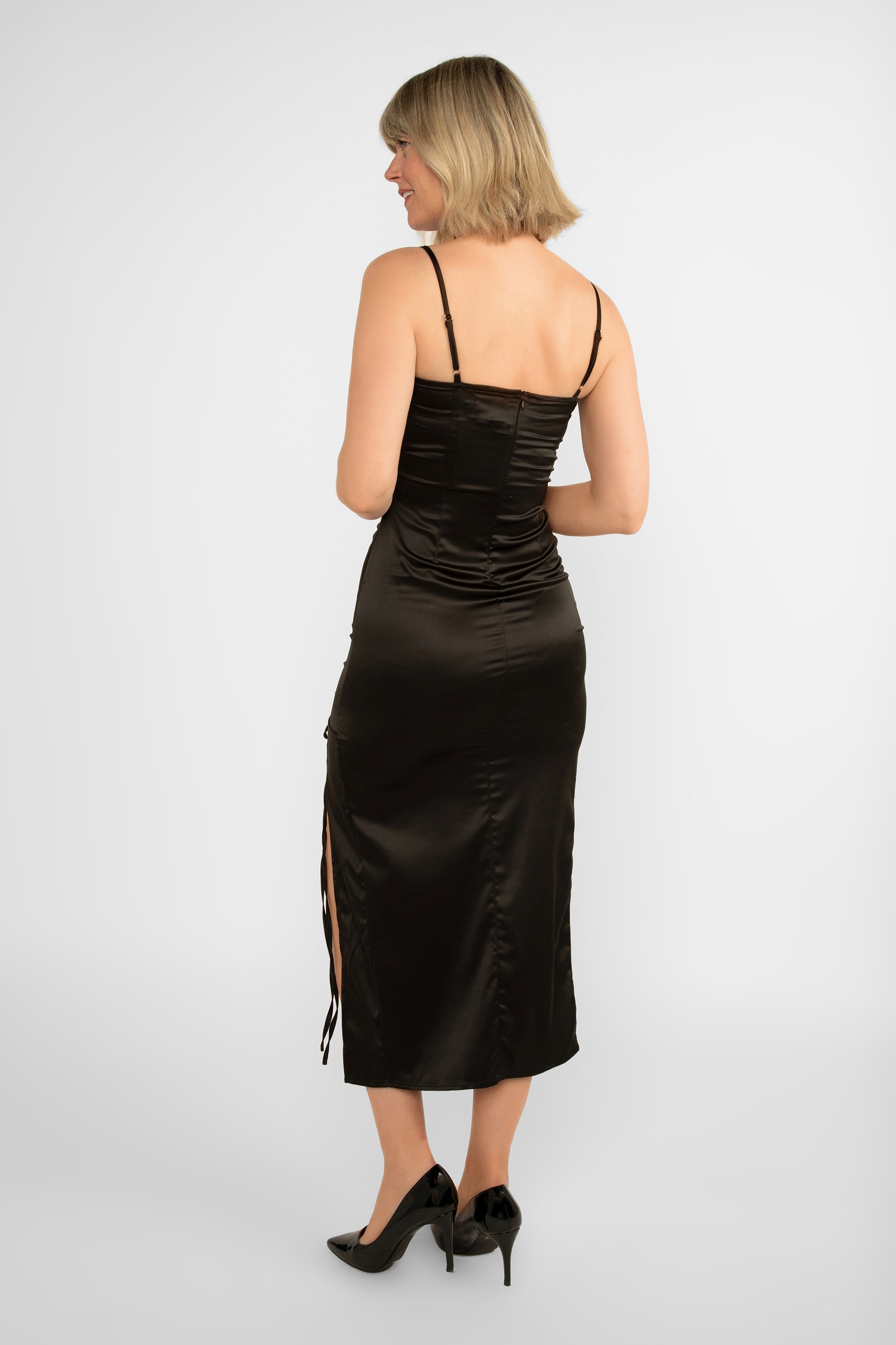 Back view of LATE (DR-2918400) Monica Dress - Satin Midi Body Con Dress with High Side split and curve accentuating ruching in Black