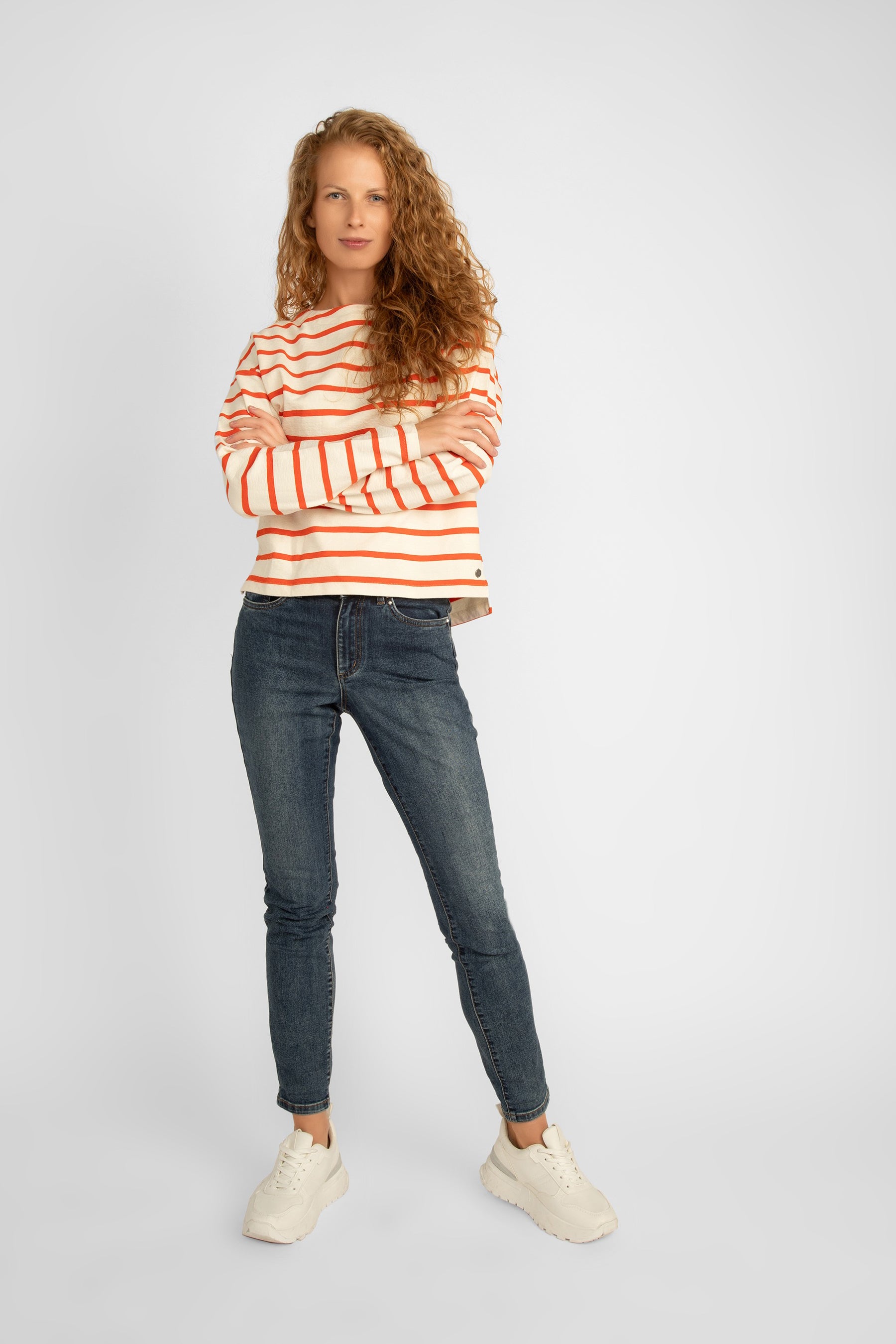 Full body front view of  Garcia (N40260) Women's Recycled Cotton Boatneck Long Sleeve Top in cream with orange stripes with jeans