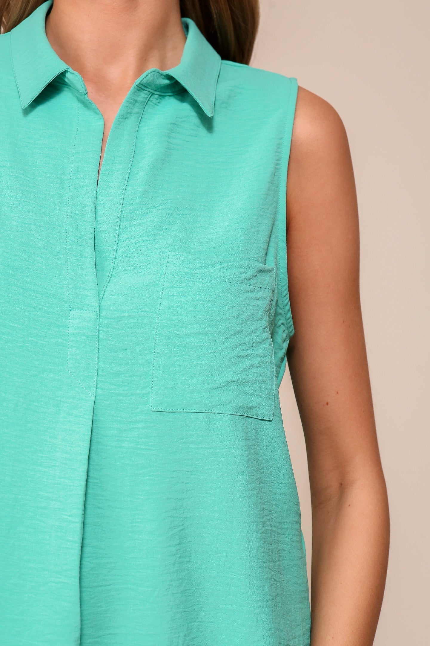Front close up of chest pocket on Timing (WN9713) women's Sleeveless Collared V-Neck Top with Chest Pocket and Flared Silhouette in JAde Green